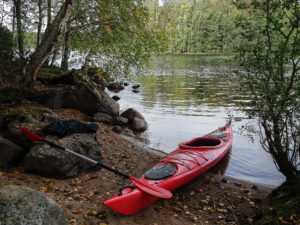 Punainen kajakki Kirkkoniemen laavun hiekkarannalla, Tarvaala, Laukaa. Kuva: Upe Nykänen