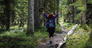 Iloinen retkeilijä nauttii luonnosta Pyhä-Häkin kansallispuiston polulla